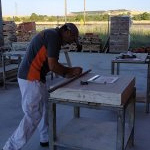 Proceso de talla del escudo en piedra natural en taller