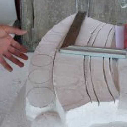 Proceso de talla del escudo en piedra natural en taller. Corte y cincelado corona