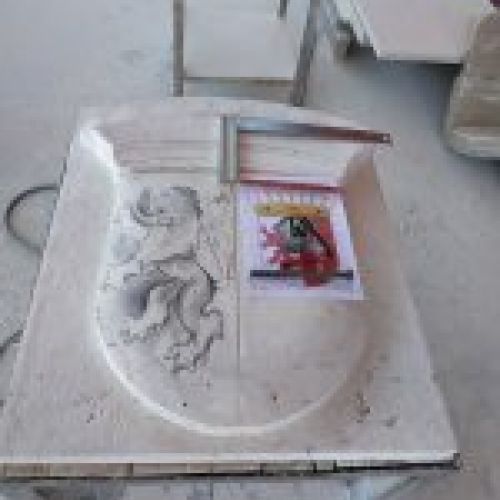 Proceso de talla del escudo en piedra natural en taller. Dibujo detalles