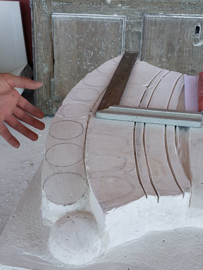 Proceso de talla del escudo en piedra natural en taller. Corte y cincelado corona