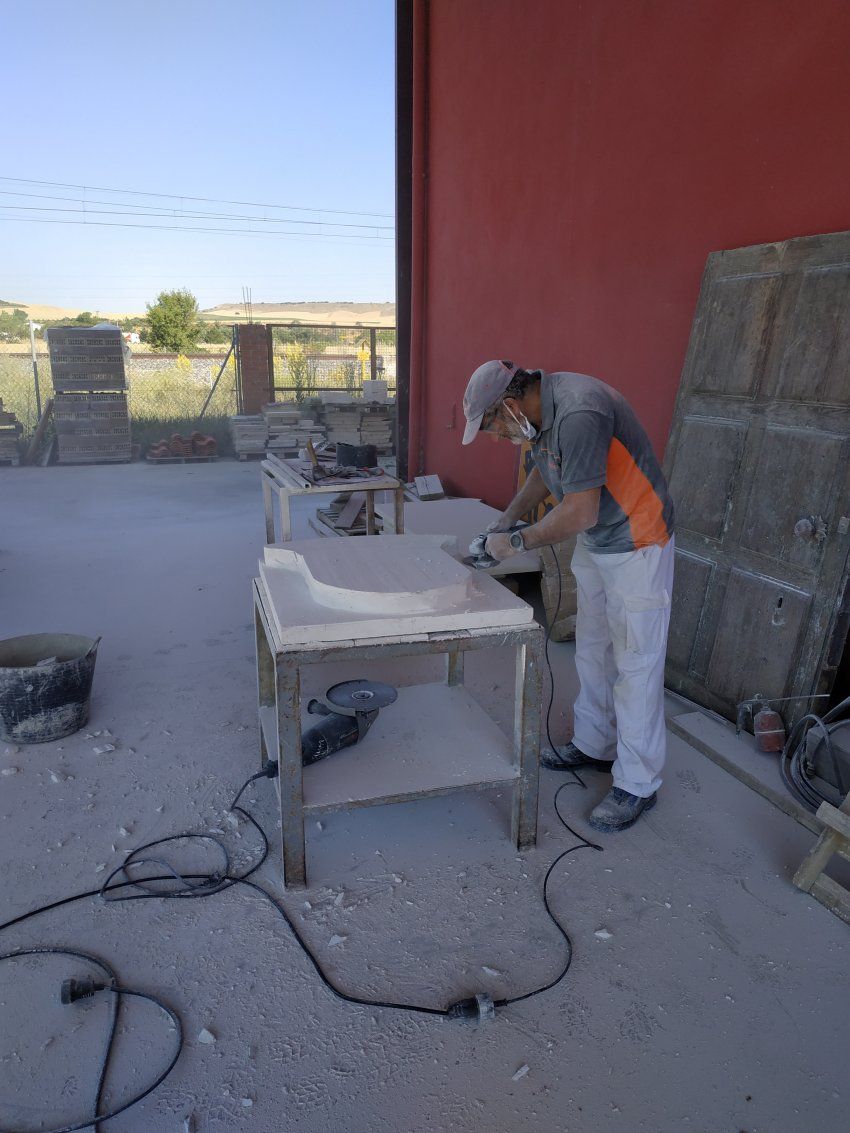 Proceso de talla del escudo en piedra natural en taller. Corte