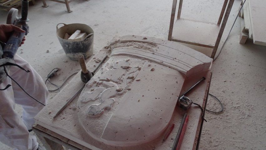 Proceso de talla del escudo en piedra natural en taller