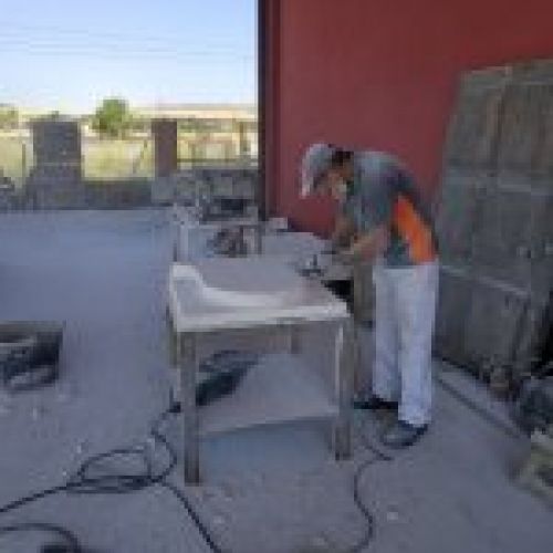 Proceso de talla del escudo en piedra natural en taller. Corte