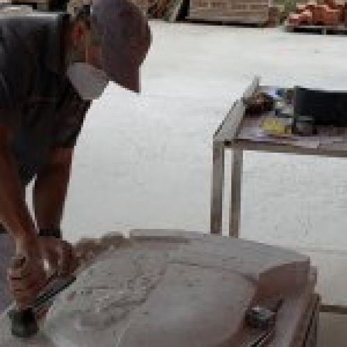 Proceso de talla del escudo en piedra natural en taller. Cincelado detalles